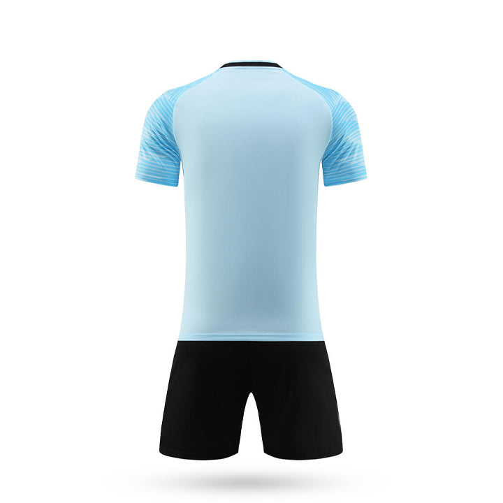 Rear view of the light blue youth soccer jersey kit with solid back panel and black athletic shorts.