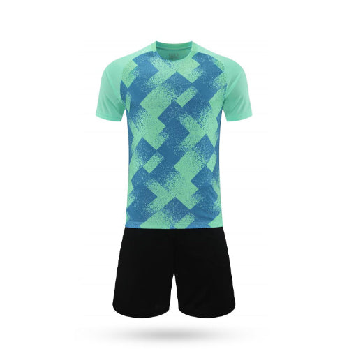 Teal green Torque Pass soccer kit with a blue-toned geometric overlay and solid black shorts.
